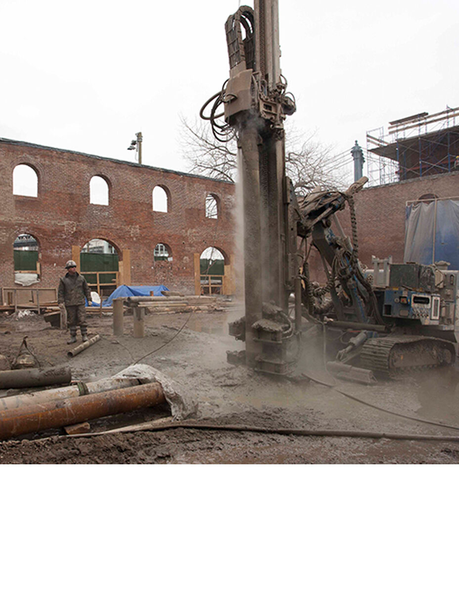 piling machine in a construction site digging into dirt